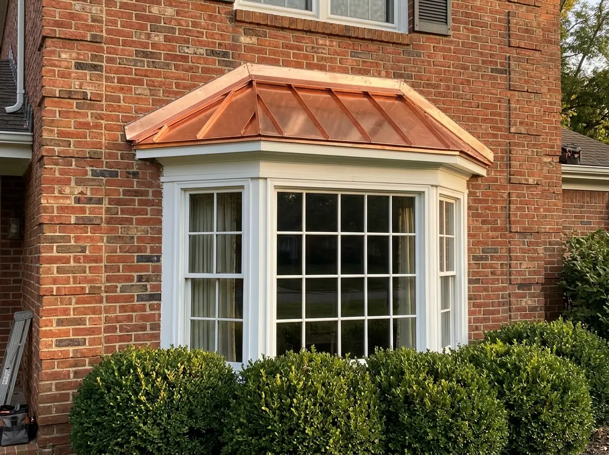 Copper standing seam roof over a bay window on a brick house