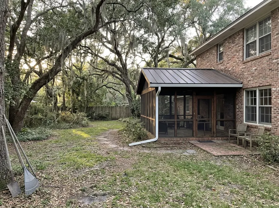 Low-slope bronze standing seam metal roof over a screened back porch