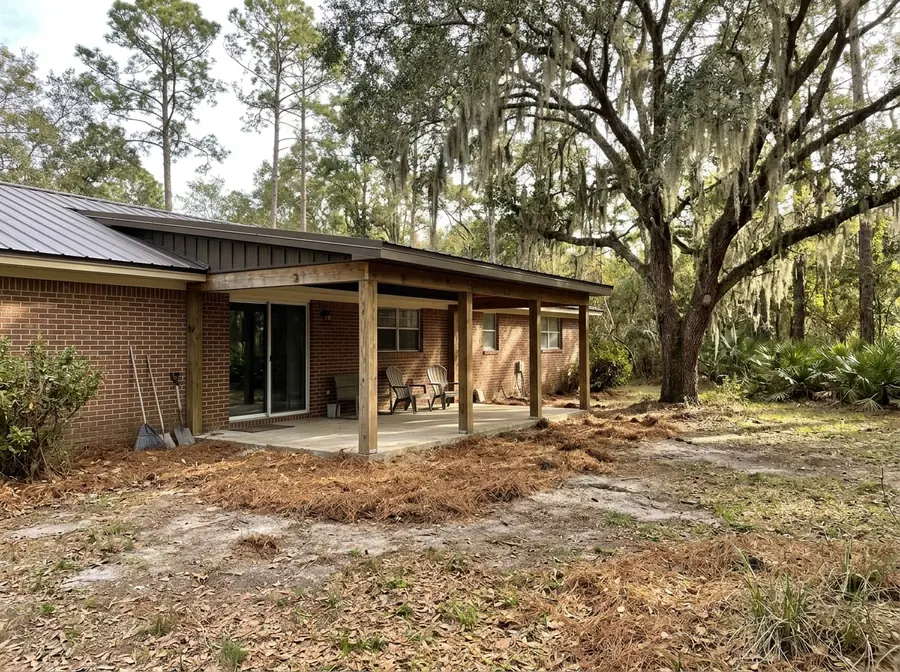 Single-slope metal roof over a new back porch addition on a brick ranch house