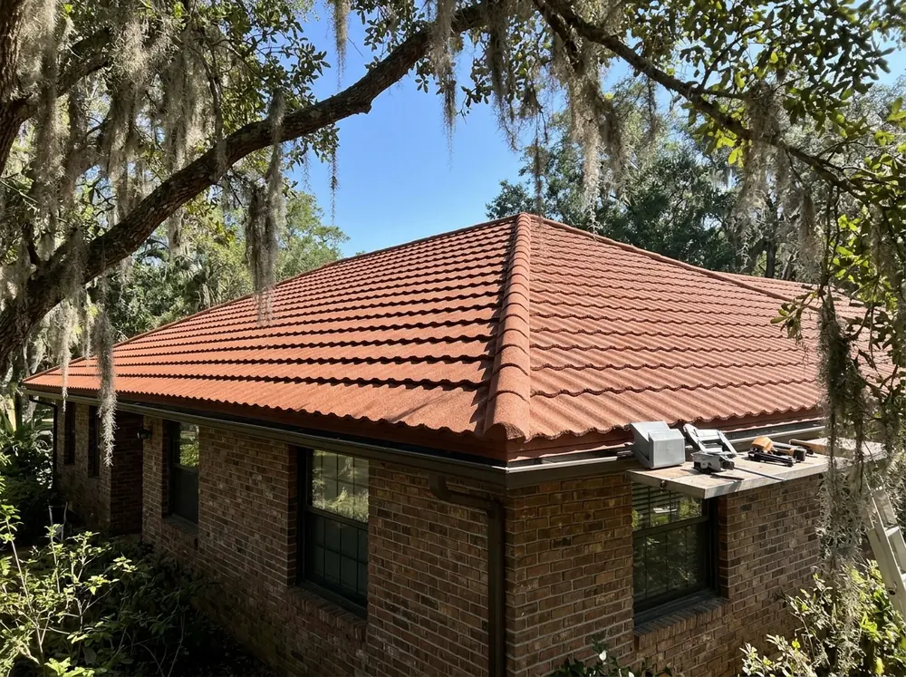 Terracotta-colored stone-coated steel panels in a barrel tile shape on a hip roof